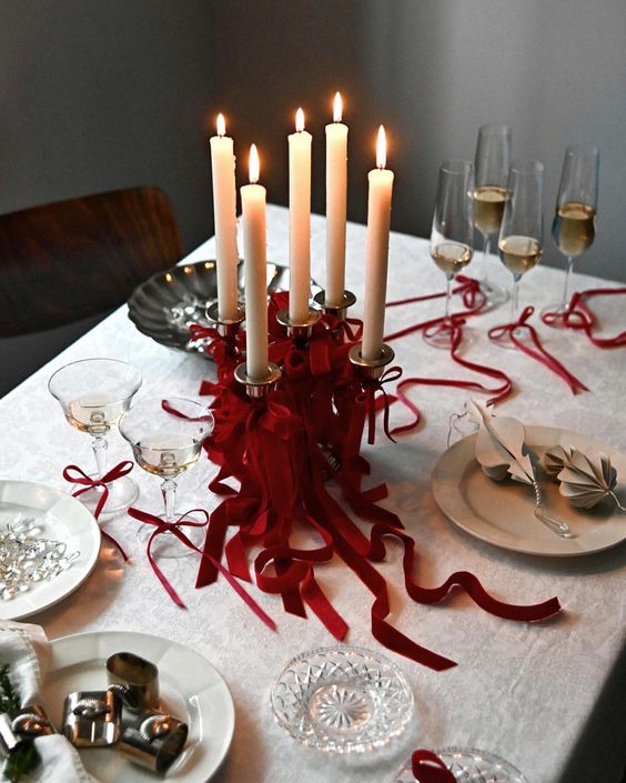 A romantic dinner setting featuring candles with red ribbons and a touch of spring elegance.