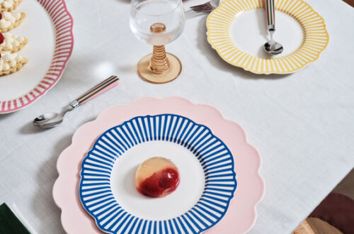 An array of colorful pastel plates with bold patterns creates a cheerful setting for a spring dinner party.