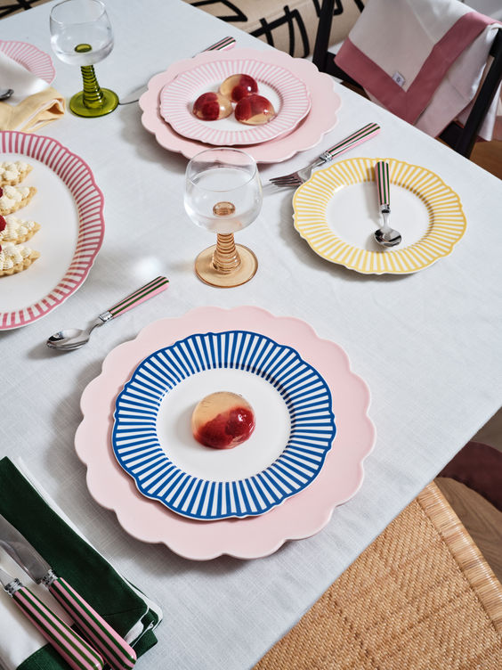 An array of colorful pastel plates with bold patterns creates a cheerful setting for a spring dinner party.