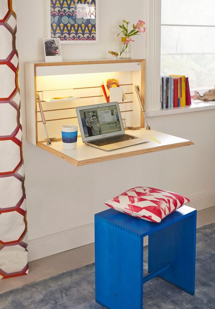 A wall-mounted desk with shelves and lighting, offering a compact workspace solution for a small bedroom.