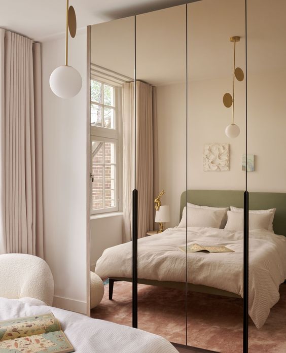 A small bedroom elegantly designed with a full-length mirrored wardrobe, creating the illusion of space.
